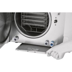 A hand pulls out a tray from an open B CLASSIC - 17 LITRES autoclave.