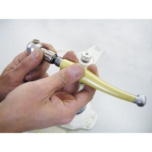 Le mani tengono il manipolo dentale DB-900 su uno sfondo chiaro.