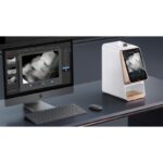 Un dispositivo i-Scan accanto a un computer visualizza le immagini radiografiche dentali.