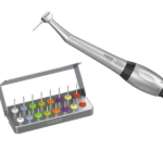 Un manipolo dentale e un set di frese dentali colorate in un supporto metallico.
