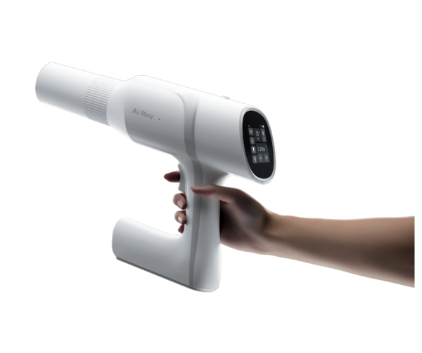 Una mano regge un Ai Ray Scanner endorale portatile con display digitale.