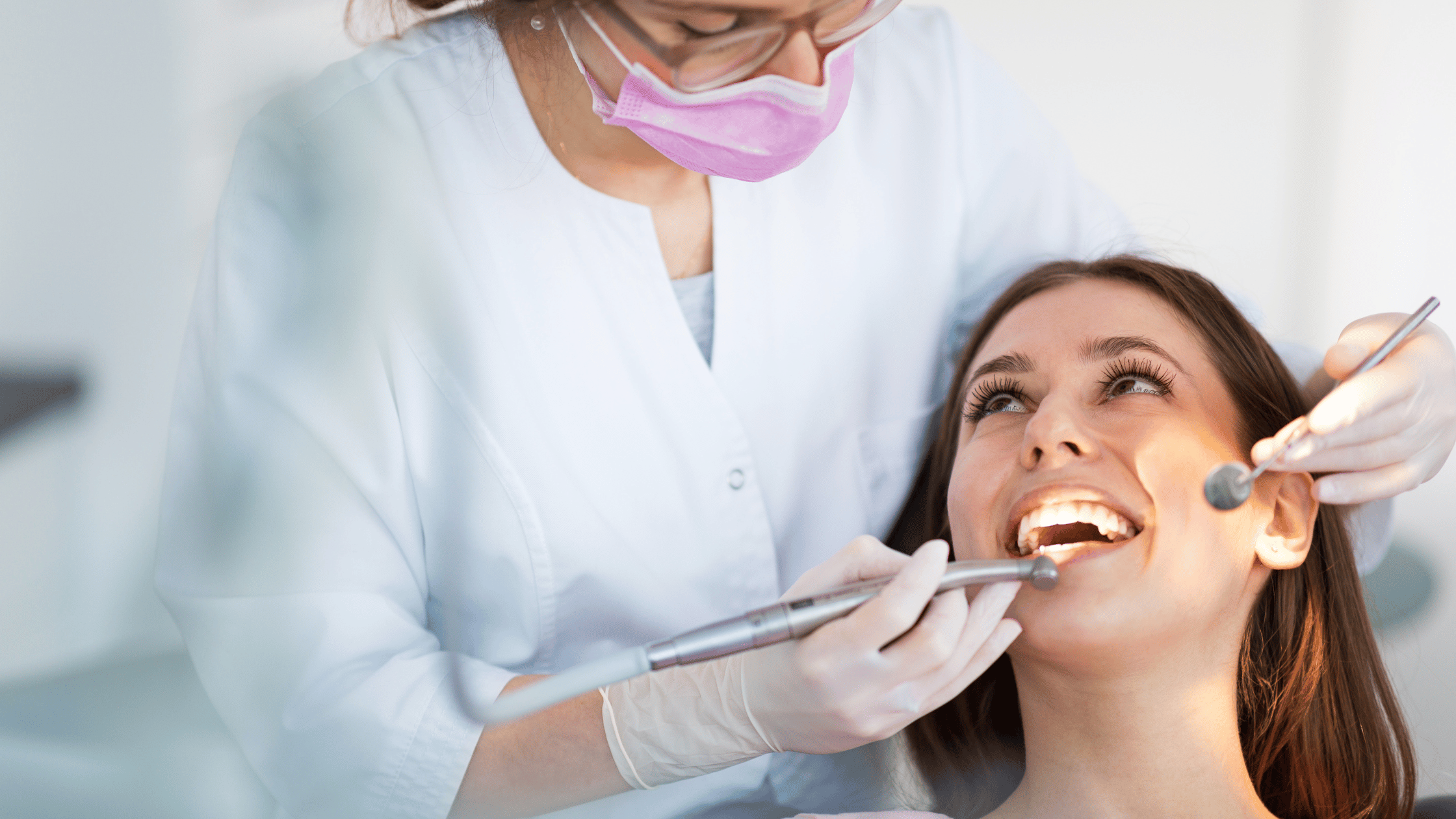 Dentista che esamina i denti di una donna sorridente per attrarre pazienti studio dentistico.