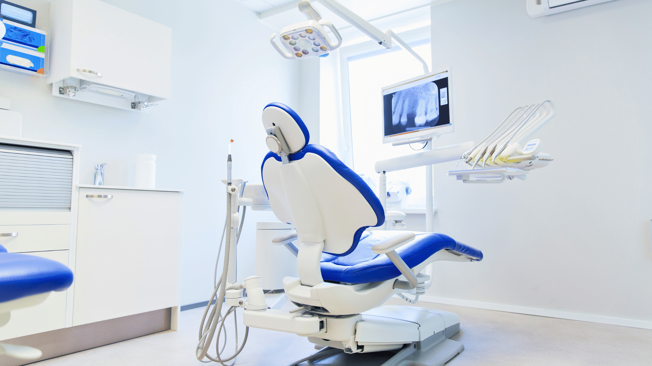 Moderna sala per esami dentistici con poltrona blu e bianca e arredamento laboratorio odontotecnico.