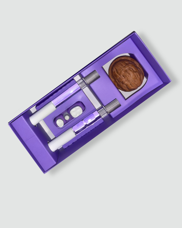 Un kit di abilità ABC viola con all'interno due penne bianche, quattro pillole e una sola noce.